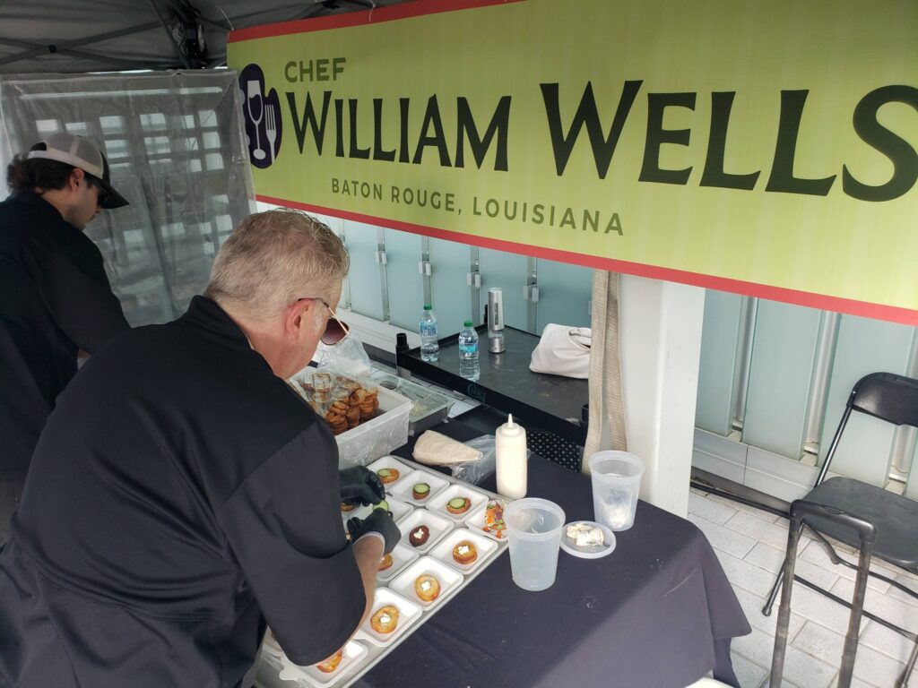 Chef William Wells preparing bite-sized appetizers at a food station during the Southern Palette Food and Drink Experience in Baton Rouge.